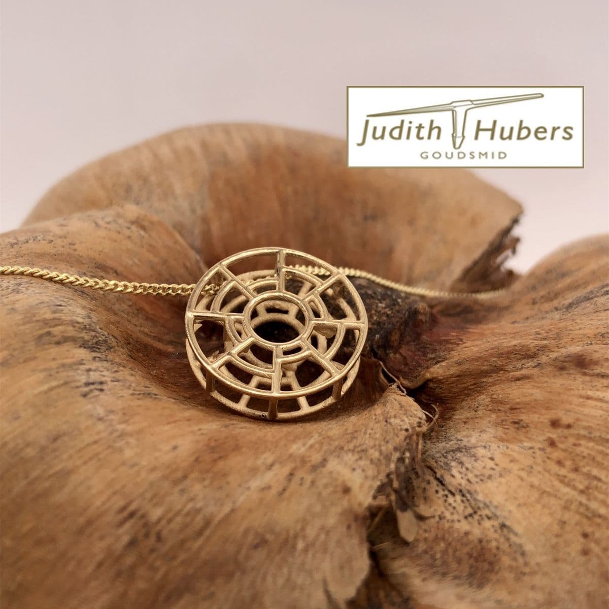 Handgemaakte geelgouden hanger met abstracte vormgeving en gourmette collier