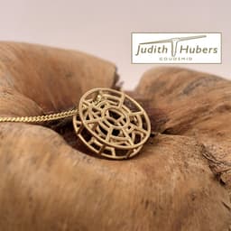 Handgemaakte geelgouden hanger met abstracte vormgeving en gourmette collier