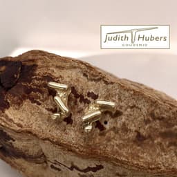 Handgemaakte geelgouden oorstekers met organische bewerking