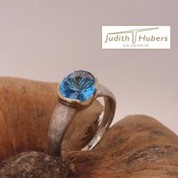 Handgemaakte zilveren ring met ovaal geslepen Fancy Topaas in een gouden zetting mt 18