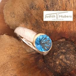 Handgemaakte zilveren ring met ovaal geslepen Fancy Topaas in een gouden zetting mt 18