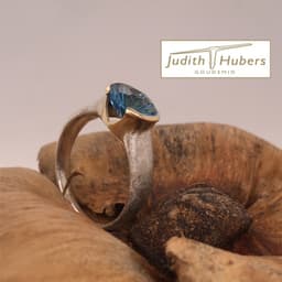 Handgemaakte zilveren ring met ovaal geslepen Fancy Topaas in een gouden zetting mt 18